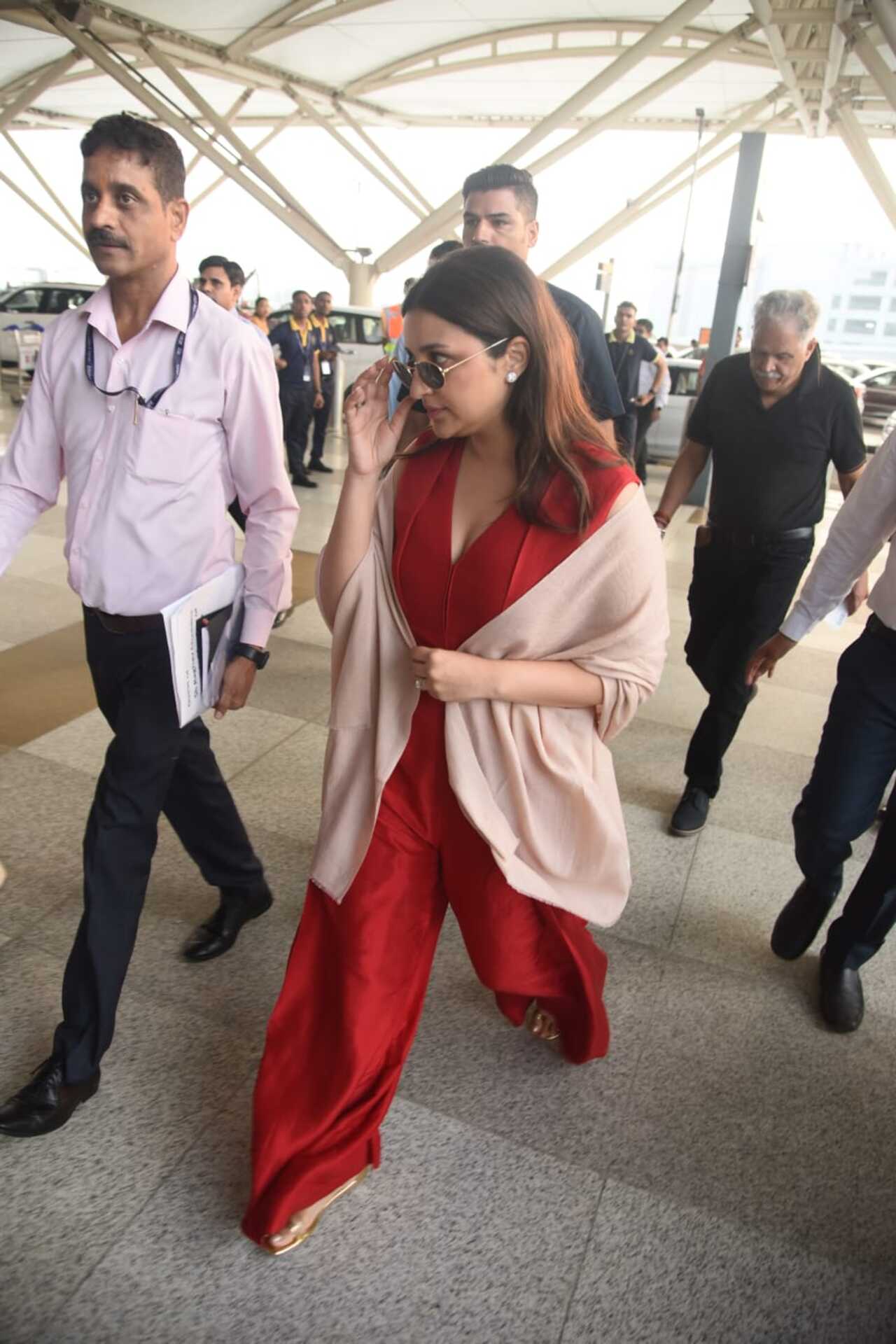 Parineeti was seen in a red jumpsuit with a peach shawl on her. She wore black shades along with her outfit. Raghav, on the other hand, was seen in a simple polo T-shirt and denims